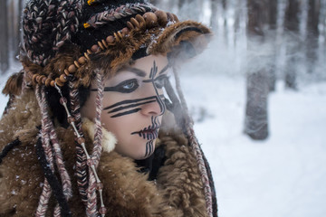 A girl in profile in a hunter's savage suit exhales couples from her mouth against the backdrop of...