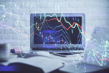 Stock market graph on background with desk and personal computer. Double exposure. Concept of financial analysis.