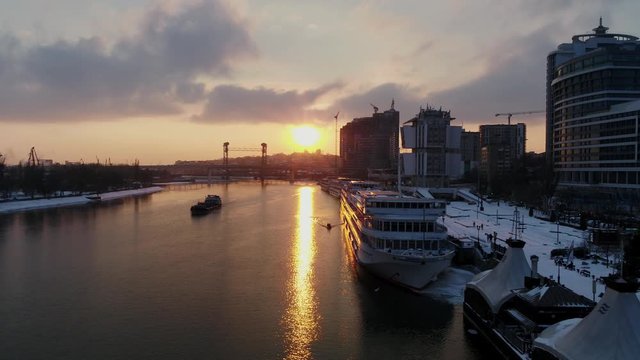 Sunset in the city over the river, ships, winter, aerial view