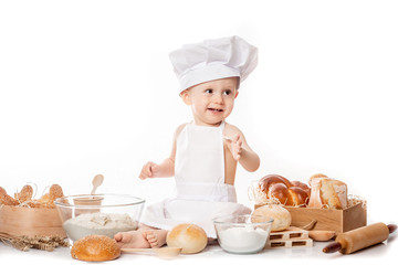 child with bread on bakery-like background wearing cook-hat