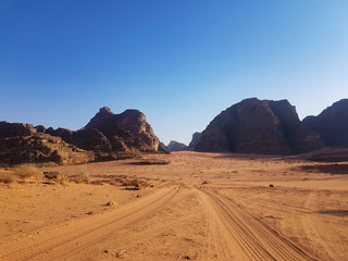 Fototapeta na wymiar Sunset in Wadi Rum desert. The surface of Mars. Safari ride on pick up trucks. 
