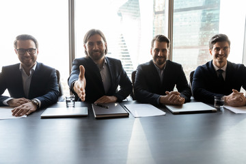 Smiling businessman stretch hand greeting with employee