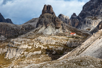Mountain landcape: a tiny mountain hut in the Dolomites and a hiking trail to it, National Park Tre Cime di Lavaredo, also know as Drei Zinnen or Three Peaks of Lavaredo. Italy, South Tyrol. 