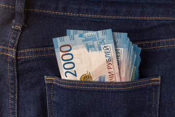 Bunch of 2000 rouble banknotes in the back pocket of a blue jeans.