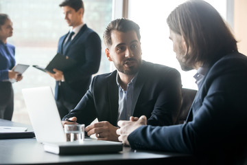 Businessmen brainstorm working together on laptop at briefing