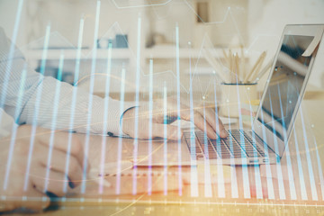 Multi exposure of stock market graph with man working on laptop on background. Concept of financial...
