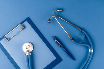 Medical stethoscope on classic blue background top view