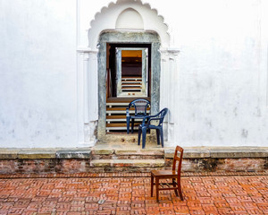 White interior courtyard wall with arched stone doorways and windowsin Kathmandu palace 
