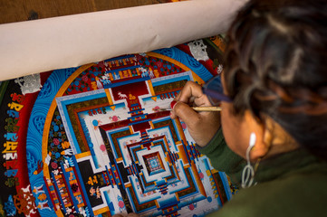 Woman painting Nepalese mandala