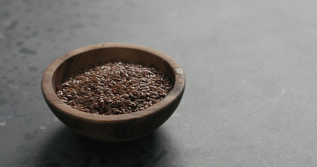 flaxseed in olive bowl on terrazzo countertop with copy space