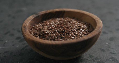 flaxseed in olive bowl on terrazzo countertop with copy space