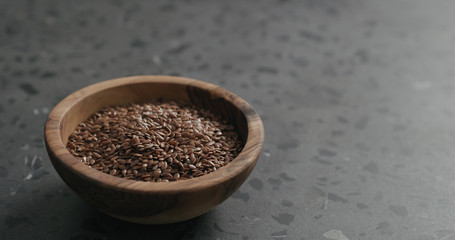 flaxseed in olive bowl on terrazzo countertop with copy space