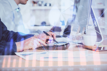 Forex graph with businessman working on computer in office on background. Concept of hardworking. Closeup. Multi exposure.