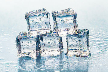 Square melting ice cubes on wet table