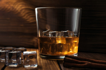 whiskey with ice on a dark wood background