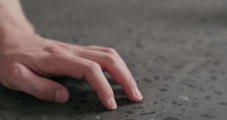 closeup man finger tapping on terrazzo countertop