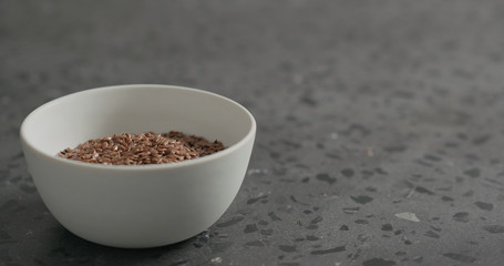 flaxseed in white bowl on terrazzo countertop with copy space