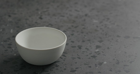 empty white bowl on gray terrazzzo countertop