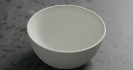 empty white bowl on gray terrazzzo countertop