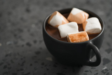 cup of hot chocolate with marshmallow on terrazzo background