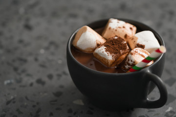 cup of hot chocolate with marshmallow on terrazzo background
