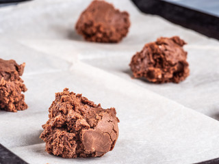 Chocolate brownie dough on ball-shaped baking paper.