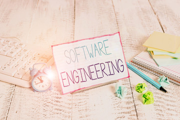 Word writing text Software Engineering. Business photo showcasing apply engineering to the development of software Notepaper stand on buffer wire in between computer keyboard and math sheets