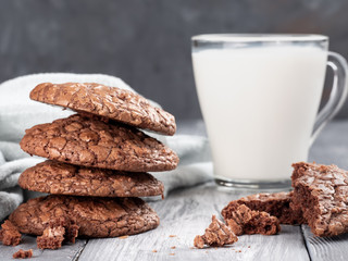 Brownie cookies on a wooden table with milk. Copy space.