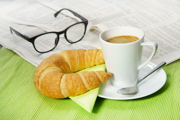 Quick breakfast with croissant and newspaper, copy space