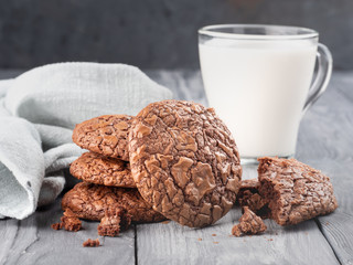 Brownie cookies on a wooden table with milk. Copy space.