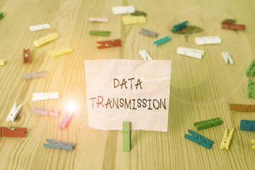 Conceptual hand writing showing Data Transmission. Concept meaning sending data electronically over a communications network Colored crumpled papers wooden floor background clothespin