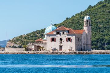 Beautiful shot of a church in the distance near a forested mountain in  Kotor, Montenegro