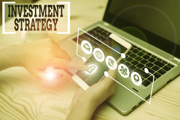 Conceptual hand writing showing Investment Strategy. Concept meaning the systematic plan to...