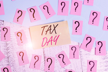 Conceptual hand writing showing Tax Day. Concept meaning colloquial term for time on which individual income tax returns Crumbling papers with thick cardboard on the wooden table