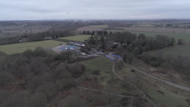 Aerial view across Pex Hill woodland walking trail &  Leighton Observatory silver dome building. Push in to descending dolly left.