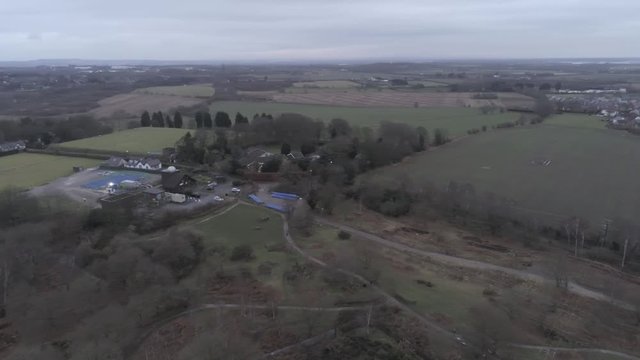Aerial view across Pex Hill woodland walking trail &  Leighton Observatory silver dome building. Pan left across landscape.