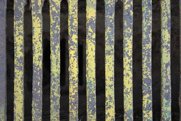 Closeup of a partly yellow metal grate for a water drain.