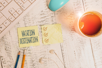 Conceptual hand writing showing Vacation Destination. Concept meaning a place where showing go for holiday or relaxation Writing equipment and computer stuff plus drinks on wooden table