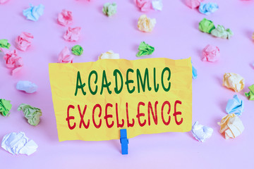Handwriting text writing Academic Excellence. Conceptual photo Achieving high grades and superior perforanalysisce Colored crumpled papers empty reminder pink floor background clothespin