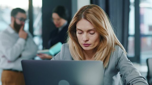 Close up of european beautiful businesswoman tired working hard on laptop upset exhausted young office work worried sleepy stressed frustrated employee corporate computer career. Portrait, slow motion