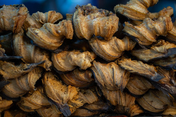 Stacking dried fishes for sale at food market.