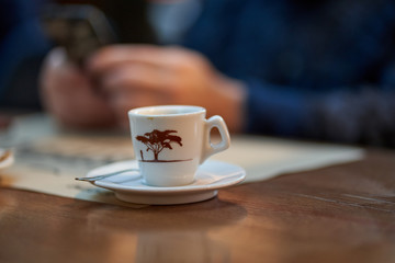Coffee cup and man using cellphone