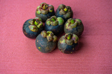 Mangosteens isolated on pink fabric
