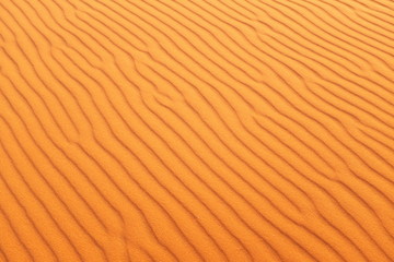 Bright orange rippled desert sand for a warm and vibrant summer background