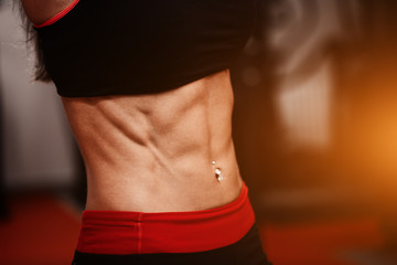 Sporty girl in gym show abs. woman in tonus.