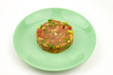 Beef Tartare cold appetizer of raw minced meat with egg yolk, spices, onions, olive oil, lemon juice