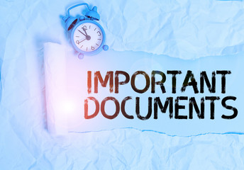 Handwriting text writing Important Documents. Conceptual photo more official pieces of paper with writing on them Alarm clock and torn cardboard placed above plain pastel table backdrop