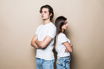 Offended guy and girl wearing beige t-shirts resenting and acting like arguing couple standing back...
