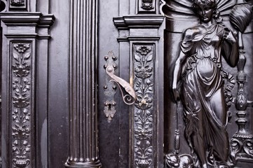 Iron handling of a decorated black door with bas-reliefs (Prague, Czech Republic, Europe)