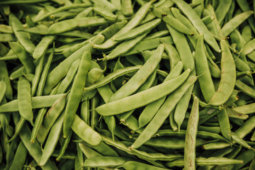 Beautiful selected organic green peas background, ripe green peas  for preparing meal, lots of green peas on a market counter.